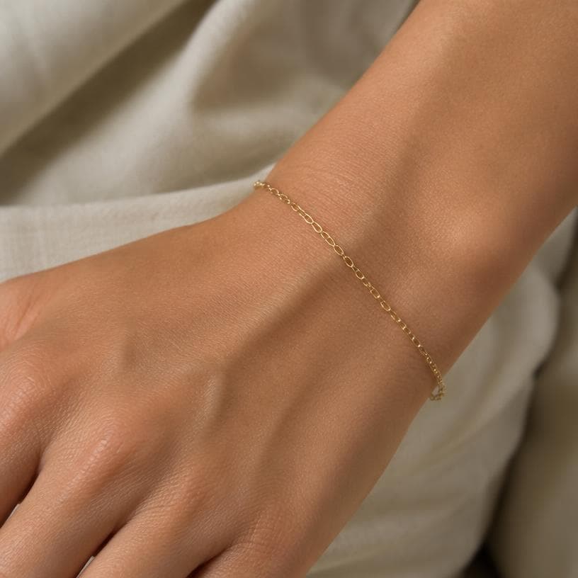 Close crop of a delicate gold chain bracelet